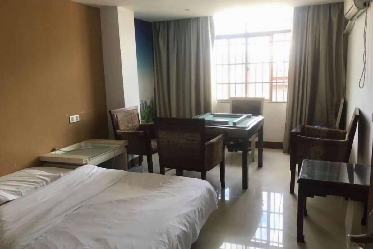 A hotel room with a bed, a desk, and a chair.