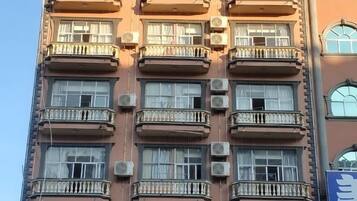 A multi-story building with balconies and air conditioning units.