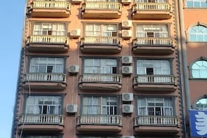A multi-story building with balconies and air conditioning units. - Hee Lingle Hotel Chains (Dongxing)
