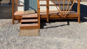 Een laag, enkelstaand gebouw met een veranda en een deur.