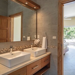 A bathroom with two sinks, a large mirror, and a wooden vanity.