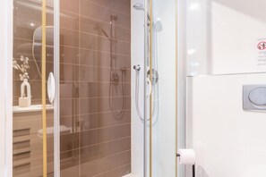 Ein modernes Badezimmer mit einer Duschkabine, einer Toilette und einem Waschbecken.