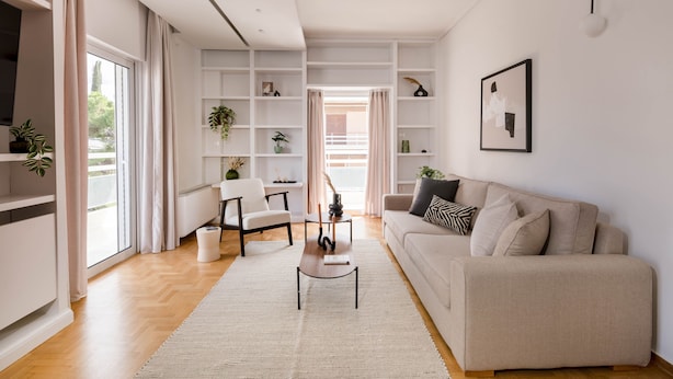 Uma sala de estar moderna com sofá, mesa de centro e estante.