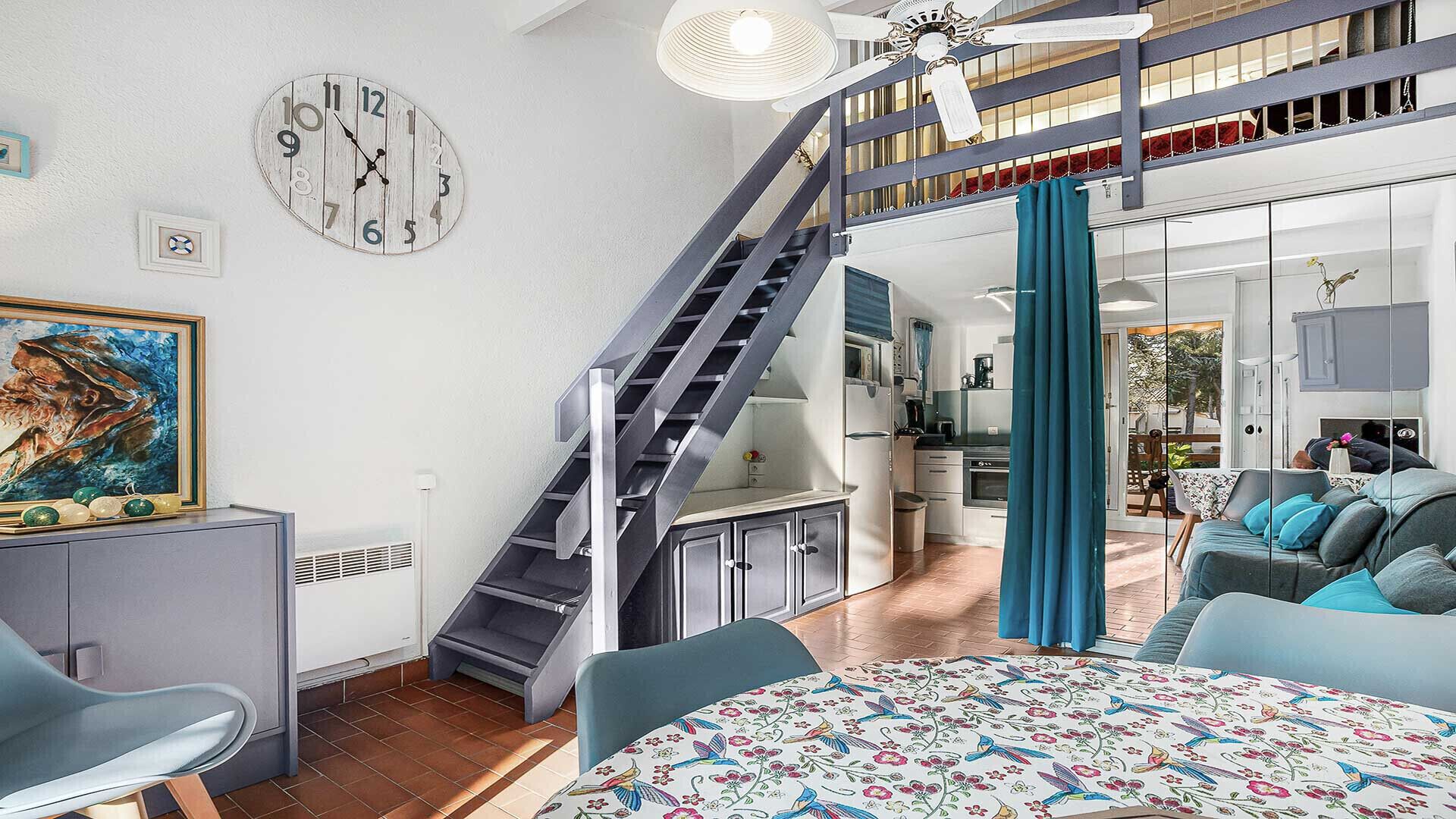 A modern interior with a staircase, a dining area, and a kitchen.