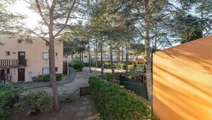 A courtyard with trees, a pathway, and buildings with balconies. - Bright apt for 4 ppl, balcony, private parking (Agde)
