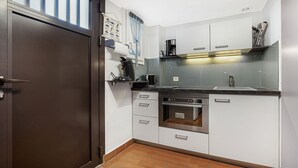 A compact kitchen with a built-in oven, a coffee maker, and a sink. - Bright apt for 4 ppl, balcony, private parking (Agde)