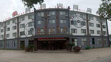 A multi-story hotel with a curved facade, large windows, and a central entrance.