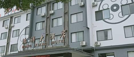 A multi-story hotel with a modern facade, featuring a prominent logo and signage.