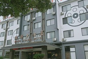 A multi-story hotel with a modern facade, featuring a prominent logo and signage.