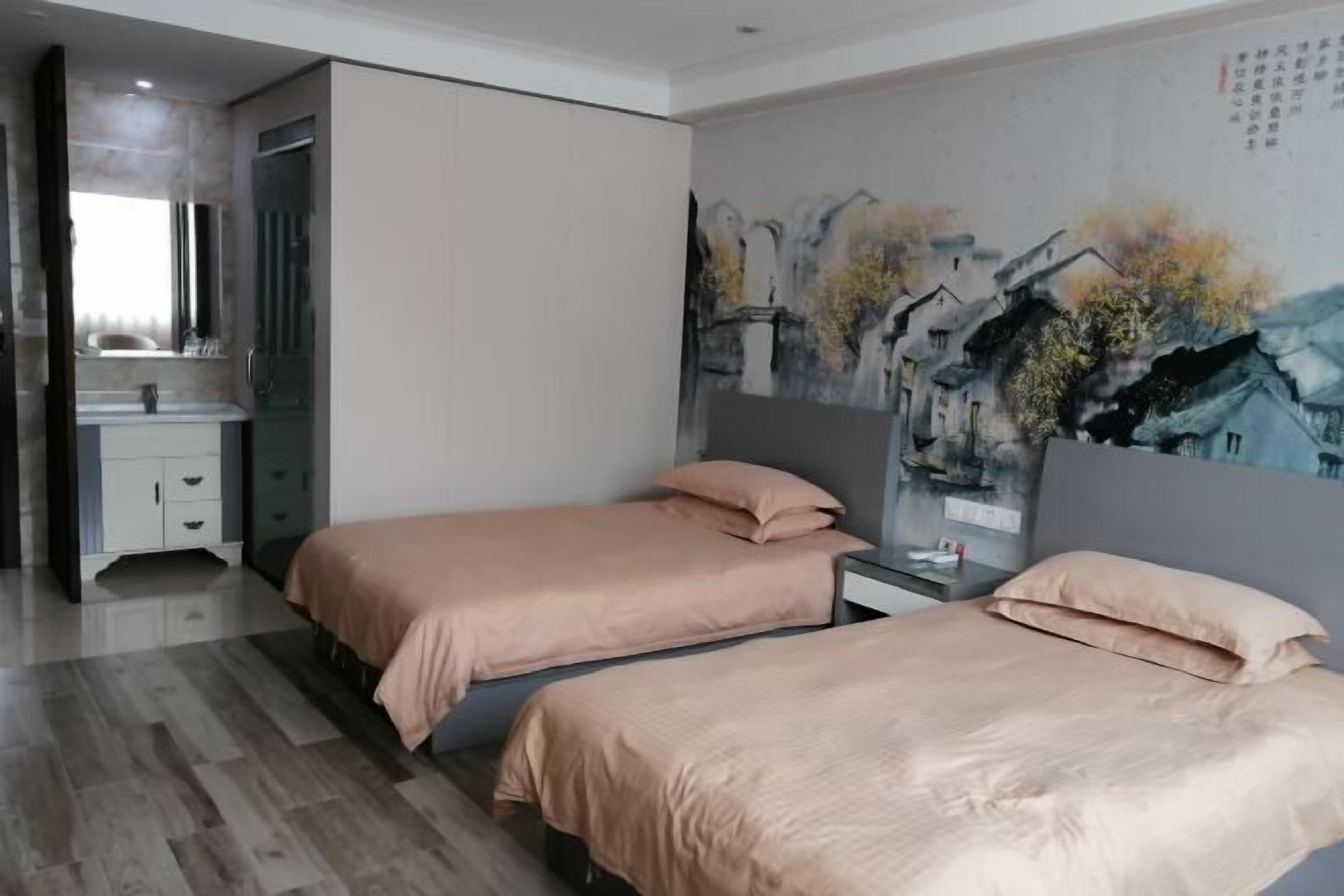 Een moderne slaapkamer met twee bedden, een groot schilderij aan de muur, en een badkamer met een glazen douche.