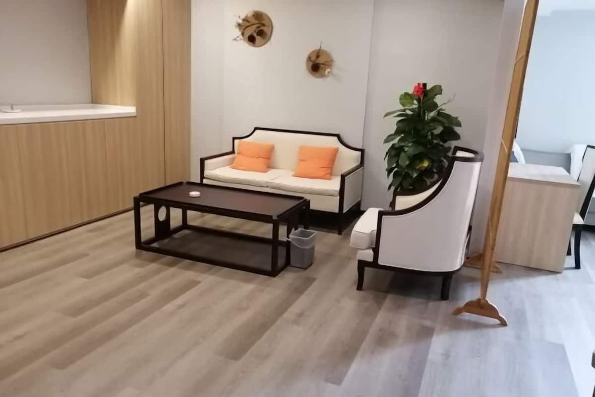 A modern living room with a sofa, coffee table, and a plant.