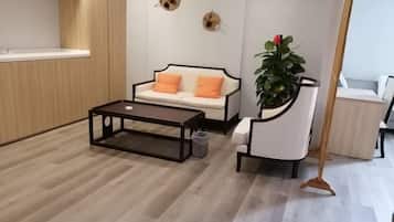 A modern living room with a sofa, coffee table, and a plant.