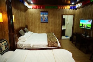 A bedroom with a bed, a television, and a door leading to another room.