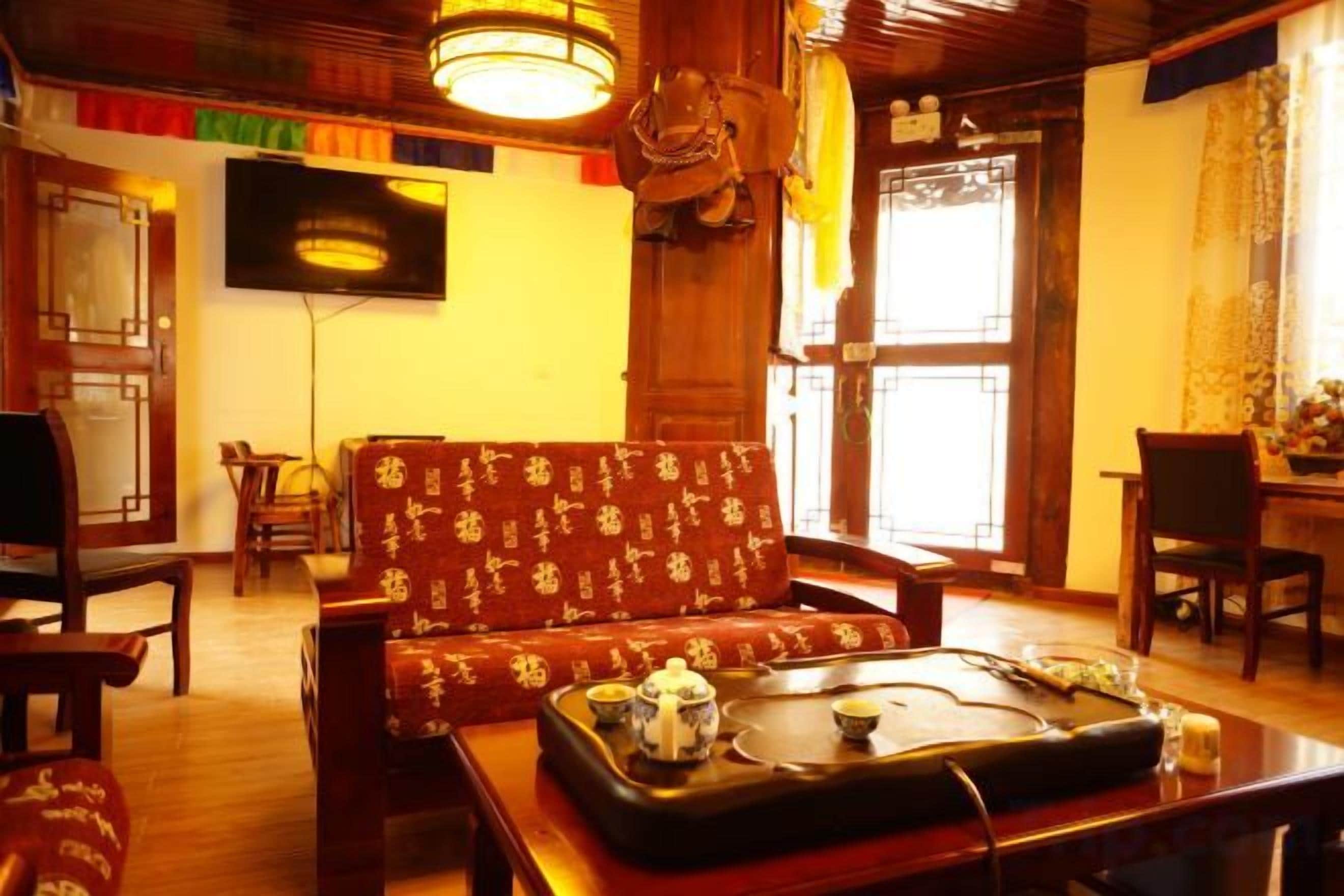 A traditional room with a sofa, dining table, and a television mounted on the wall.