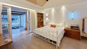 A bedroom with a white metal bed, wooden shelves, a bedside table, and a ceiling light fixture. - Yunlu Music Homestay (Zhujiajiao Scenic Area) (Shanghai)
