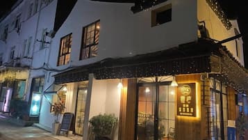 A building with a white facade, large windows, and a sign with Chinese characters.