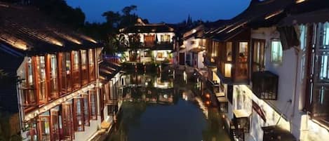 A canal-side building with multiple levels and a waterway in front.