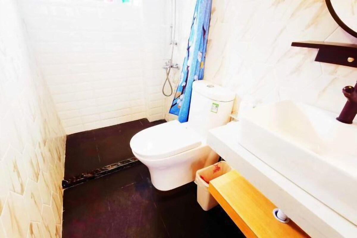 A small bathroom with a toilet, sink, and shower.