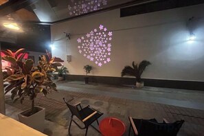 An indoor area with a wall-mounted projection of a heart-shaped pattern, potted plants, and seating arrangements. - Yunlu Music Homestay (Zhujiajiao Scenic Area) (Shanghai)