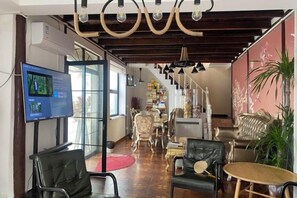 A hotel lobby with a television, seating area, and a staircase leading to upper floors. - Yunlu Music Homestay (Zhujiajiao Scenic Area) (Shanghai)