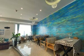 Un comedor con un mural azul, un piano y una mesa con mantel a cuadros.