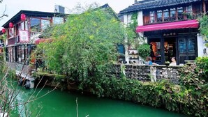 A traditional building with a red awning, a wooden bridge, and a river. - Yunlu Music Homestay (Zhujiajiao Scenic Area) (Shanghai)