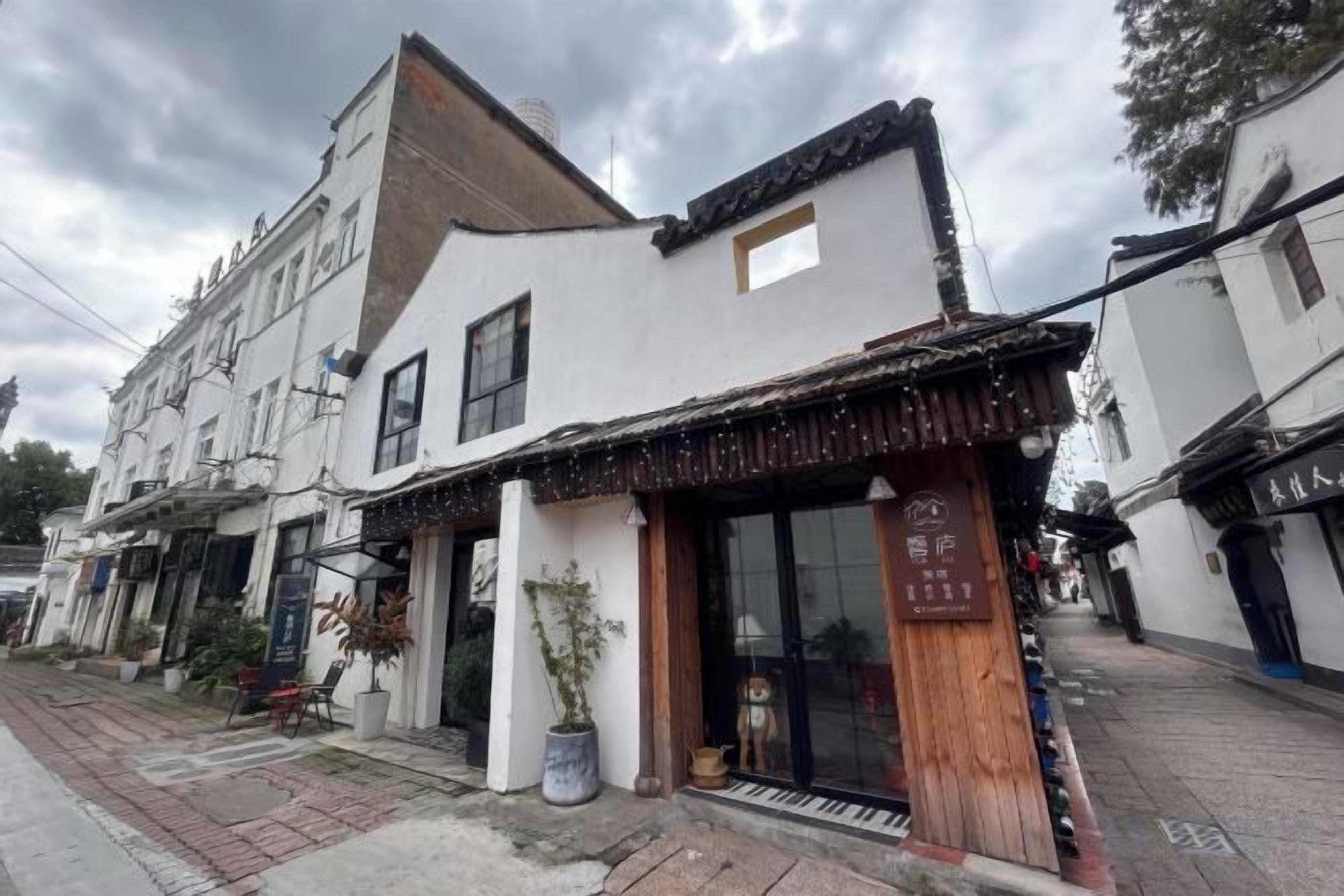 A traditional building with a storefront, large windows, and a visible entrance.