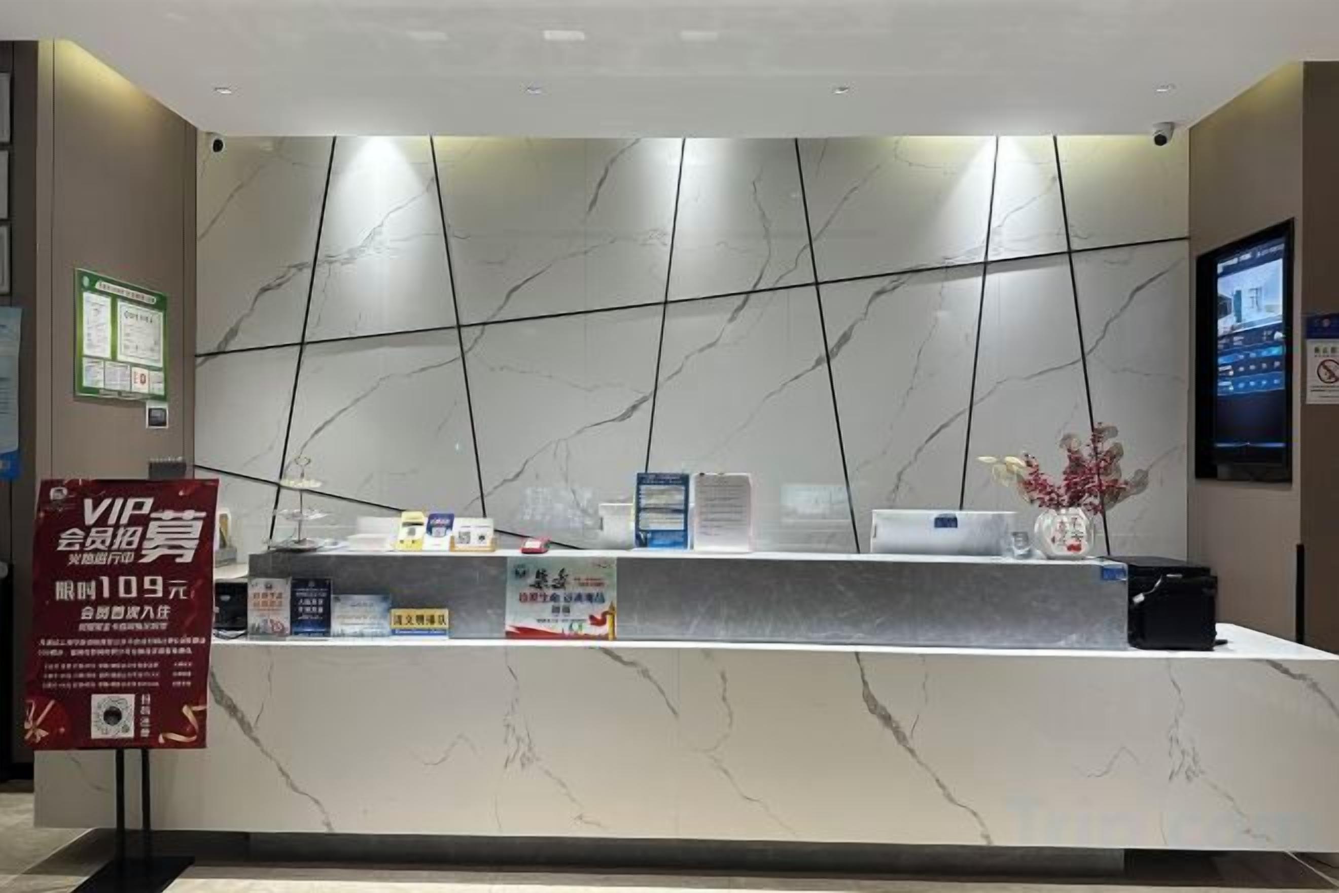 A hotel reception desk with a marble countertop, a digital screen, and a VIP sign.