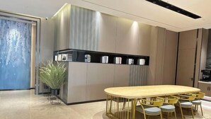 A modern kitchen with a central island, a dining area with yellow chairs, and a blue accent wall. - Huashu Yi Hotel (Pinghu Branch) (Pinghu)