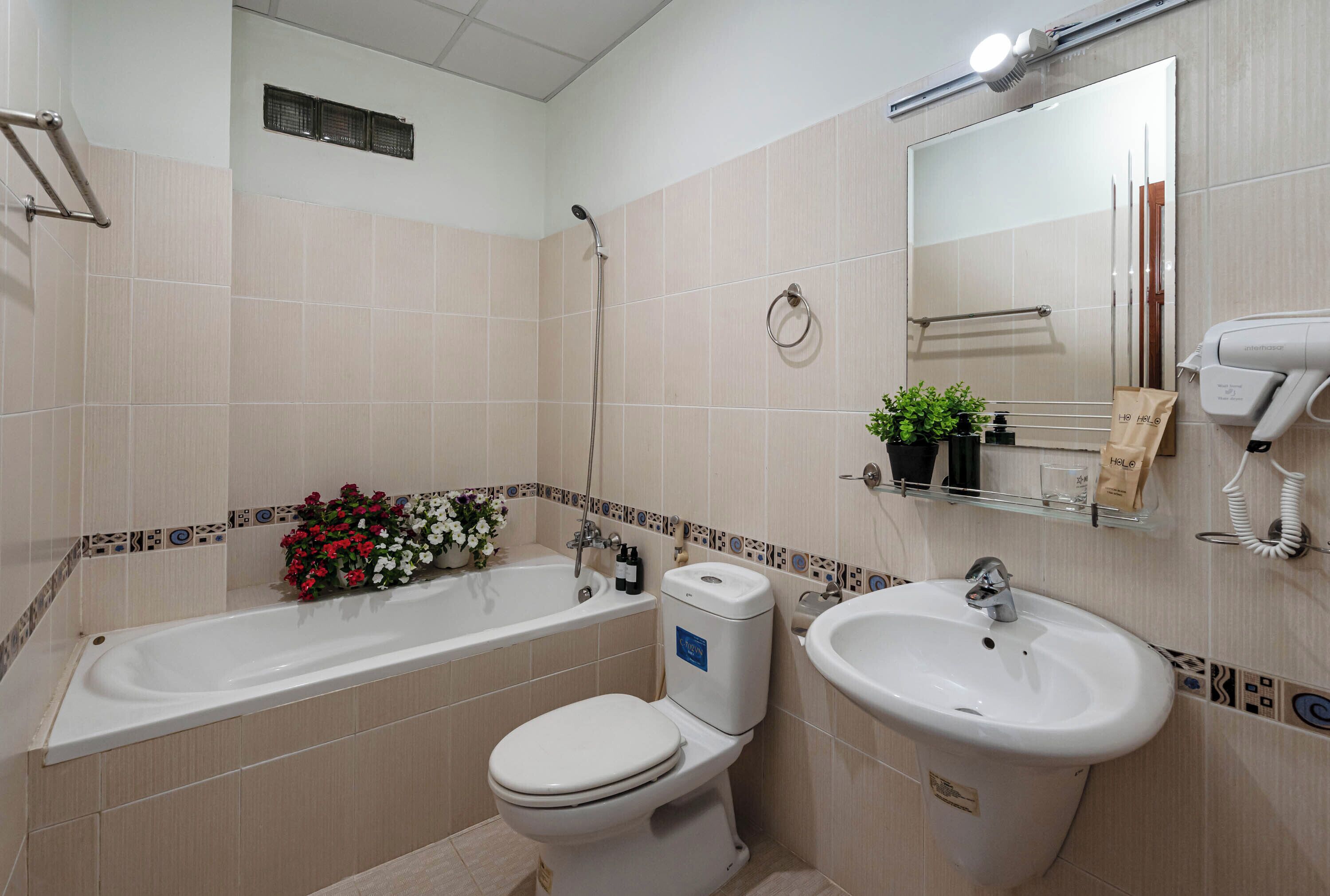 A bathroom with a bathtub, toilet, sink, and a mirror.