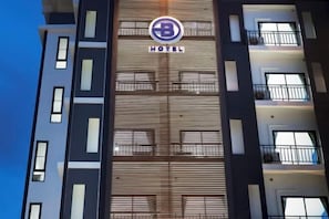 A hotel building with a prominent logo and the word "HOTEL" displayed on the facade. - B Hotel Khon Kaen (Khon Kaen)