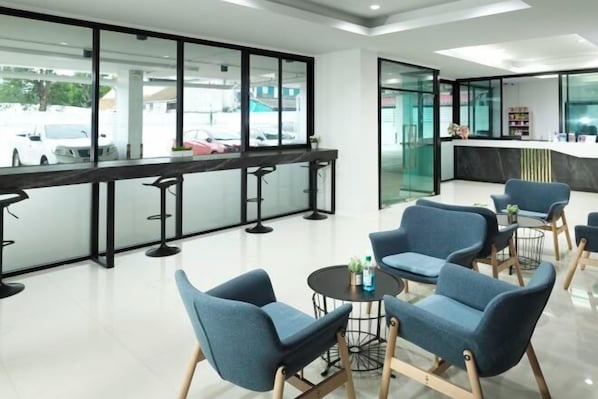 Guests can check in at the reception desk, surrounded by comfortable seating and a small table with amenities.