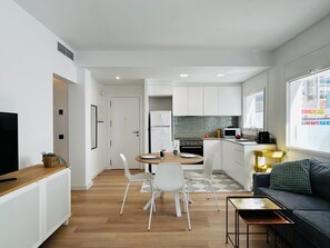 A modern apartment with a dining area, kitchen, and living space. - APARTAMENTOS AQUARIUM. (Roses)