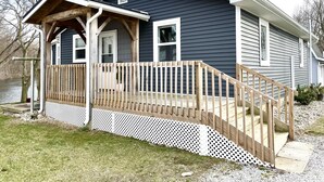 A two-story house with a wooden deck and a covered porch. - Relaxing Riverside 10 Minutes to Shipshewana (Howe)
