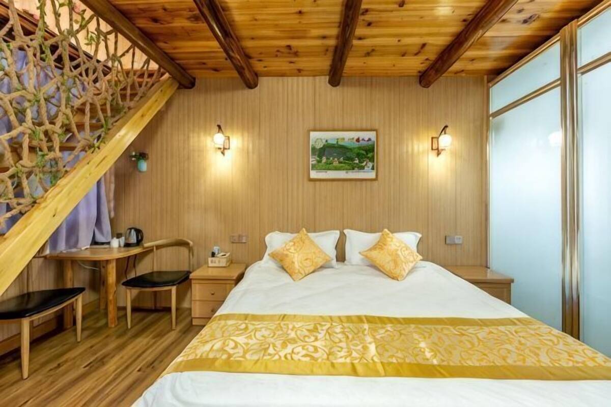 A bedroom with a bed, bedside tables, a desk, and chairs.