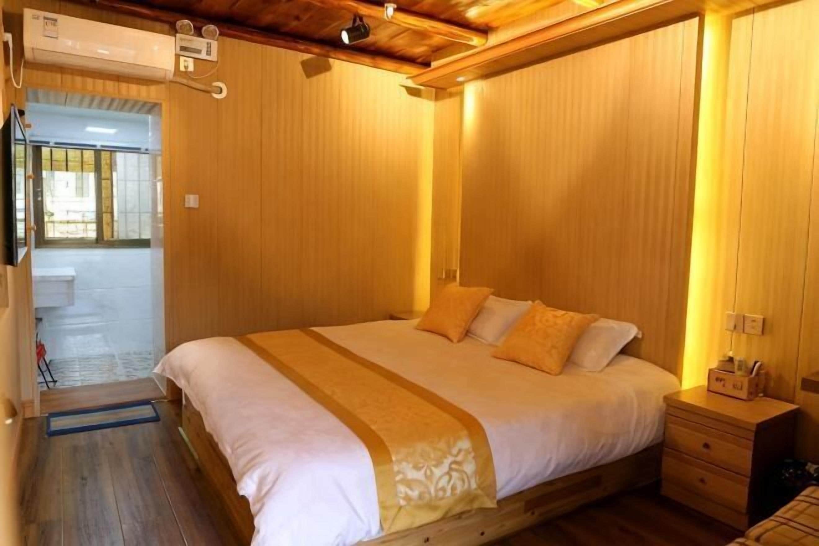 Une chambre avec un lit en bois, une table de chevet et un radiateur fixé au mur.