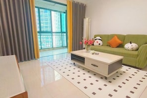 Una sala moderna con un sofá verde, una mesa de centro blanca y vistas a un balcón.