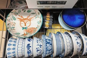 Un lavavajillas con distintos platos y cuencos de cerámica.