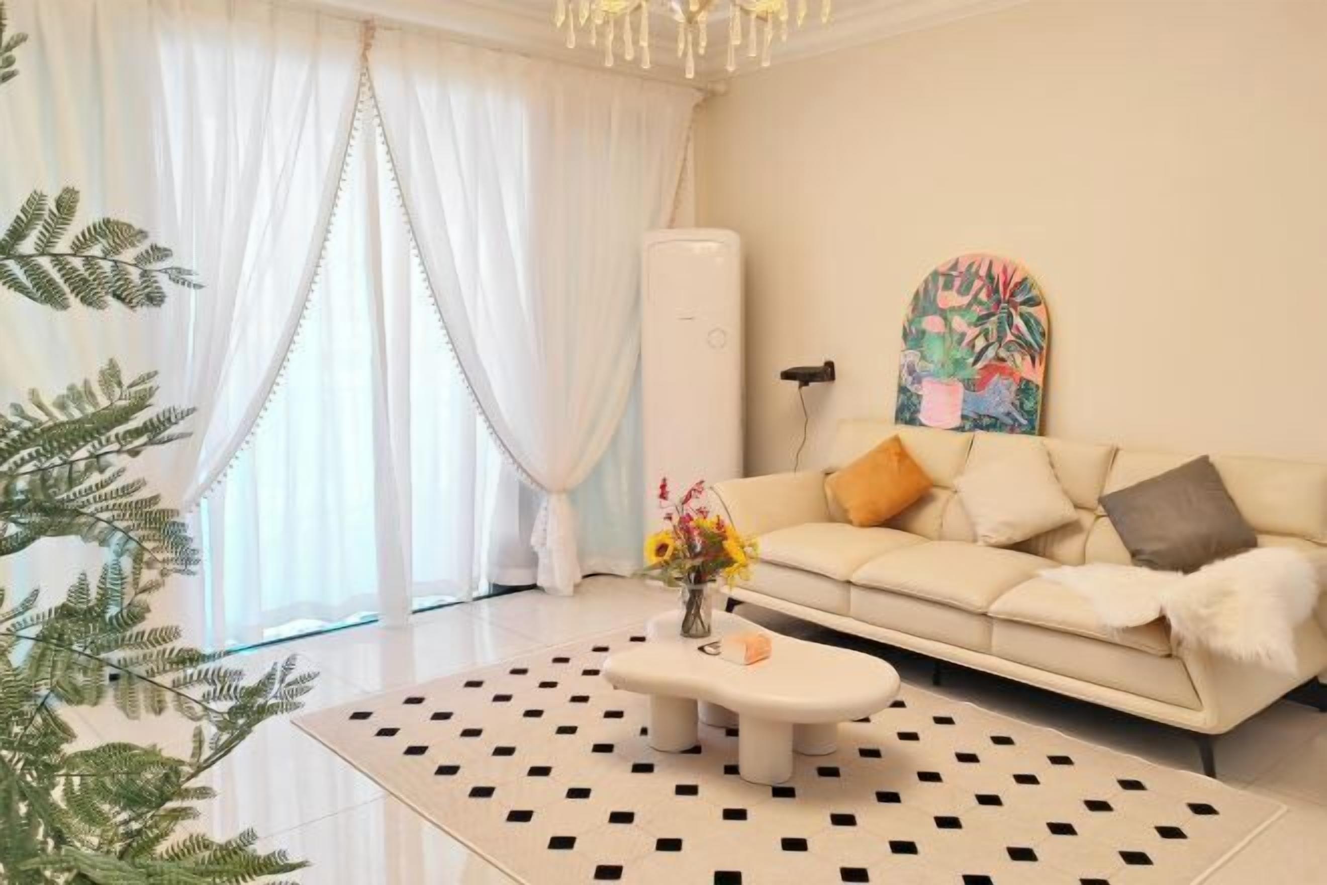 Uma sala de estar moderna com sofá, mesa de centro e uma planta decorativa.