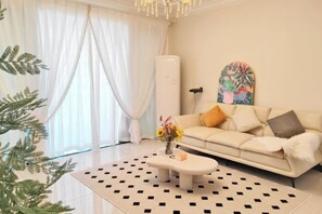 A modern living room with a sofa, a coffee table, and a decorative plant.