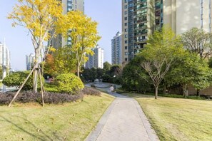 Un camino en una zona residencial, con árboles y edificios al fondo.