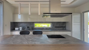 A modern kitchen with a built-in oven, a window with a view, and a minimalist design. - City Napa Seaview Villas - Villa 5, Luxury Villa (Ayia Napa)