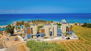 Un hotel costero de arquitectura moderna, un puerto deportivo y vistas al mar.