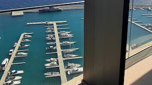 Un edificio alto con vistas a un puerto deportivo y al océano.