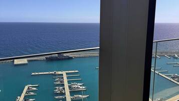 Ein Hochhaus mit Blick auf einen Yachthafen und das Meer.