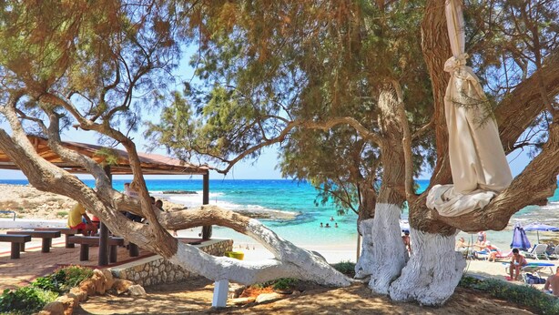 A beach scene with a wooden structure, benches, and a hammock. - Sea Pearl Beachfront Villa (Ayia Napa)