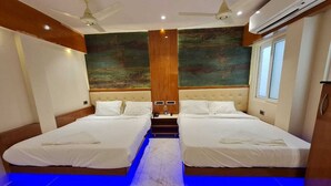 A hotel room with two beds, a wooden headboard, a marble floor, and a painting on the wall. - Hotel Sannidhi (Vijayawada)
