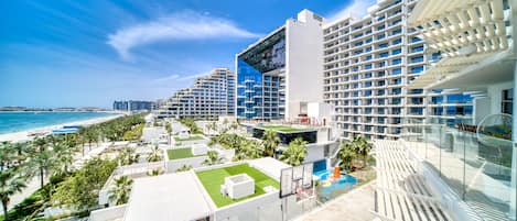 Un hotel moderno con varias plantas, una zona de piscina y vistas a la playa.