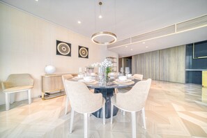 A modern dining area with a round table, four chairs, and a decorative centerpiece.