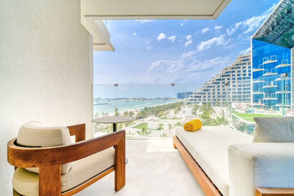 A balcony with a view of a beach and high-rise buildings.